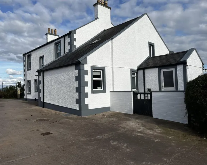 Rural farmhouse exterior painted white with charcoal grey quoins and window surrounds