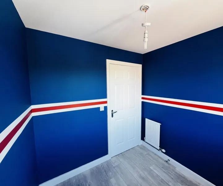Bedroom painted royal blue with a hand-painted red and white stripe