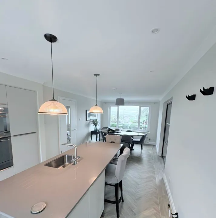 Bright kitchen-diner with freshly painted light grey walls and white ceiling