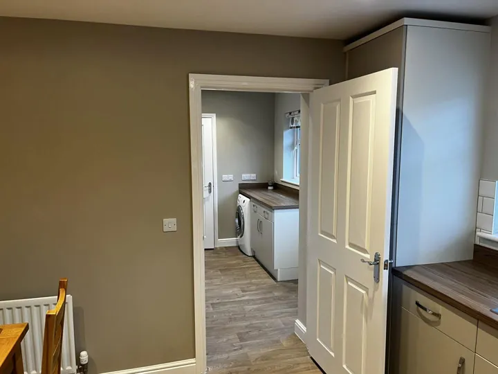 Kitchen wall in a warm neutral tone with white painted door and frame